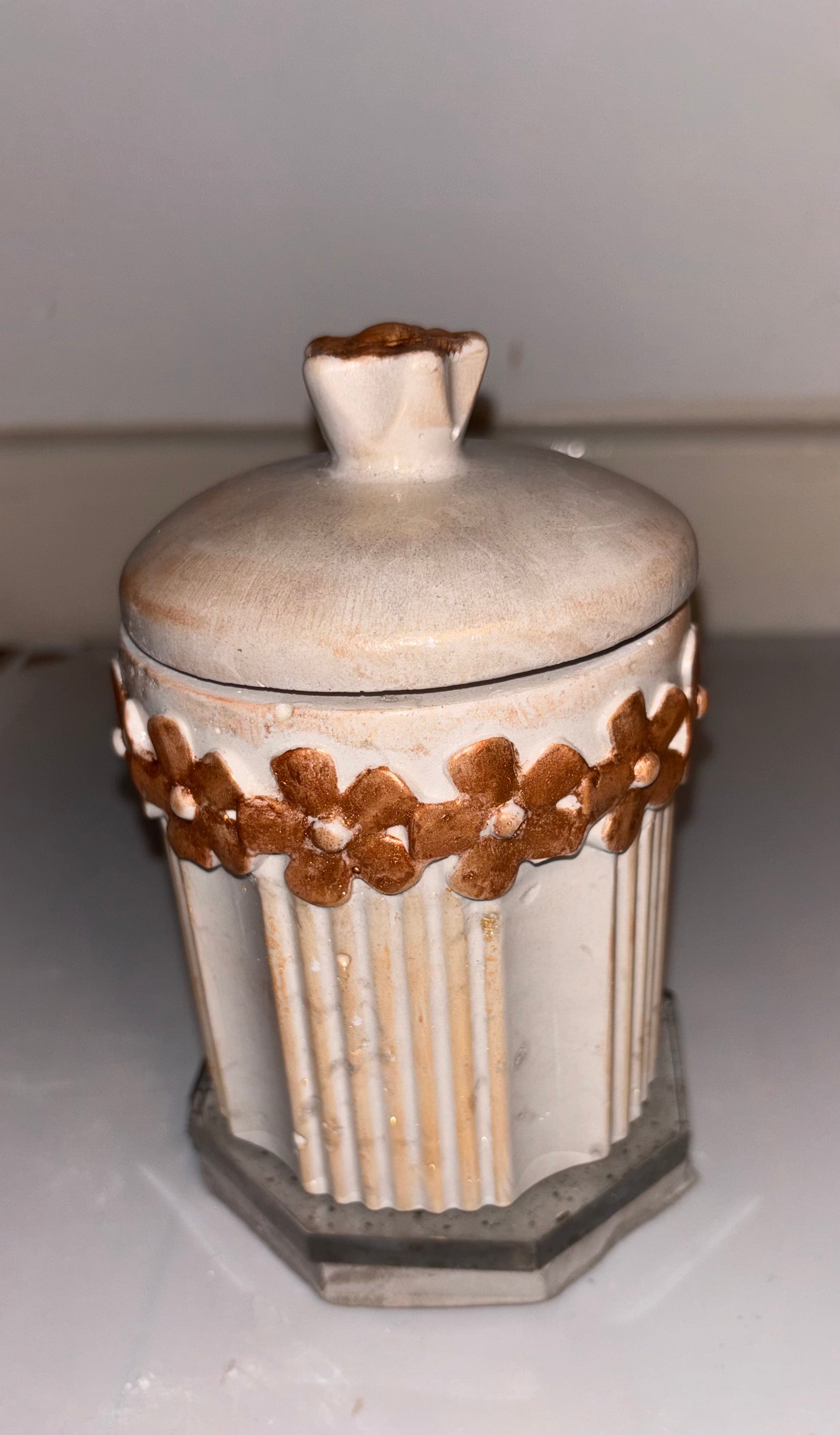 Pote artesanal octogonal creme com guirlanda de flores douradas em relevo e tampa arredondada